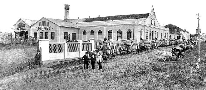 Engenho Tibagy, localizado no Batel, fundado pelo Barão do Serro Azul. Na sua frente aparece um conjunto de bondes de mulas, carregados com barricas de mate destinadas à Estação da Estrada de Ferro. Foto do início de 1900 | 