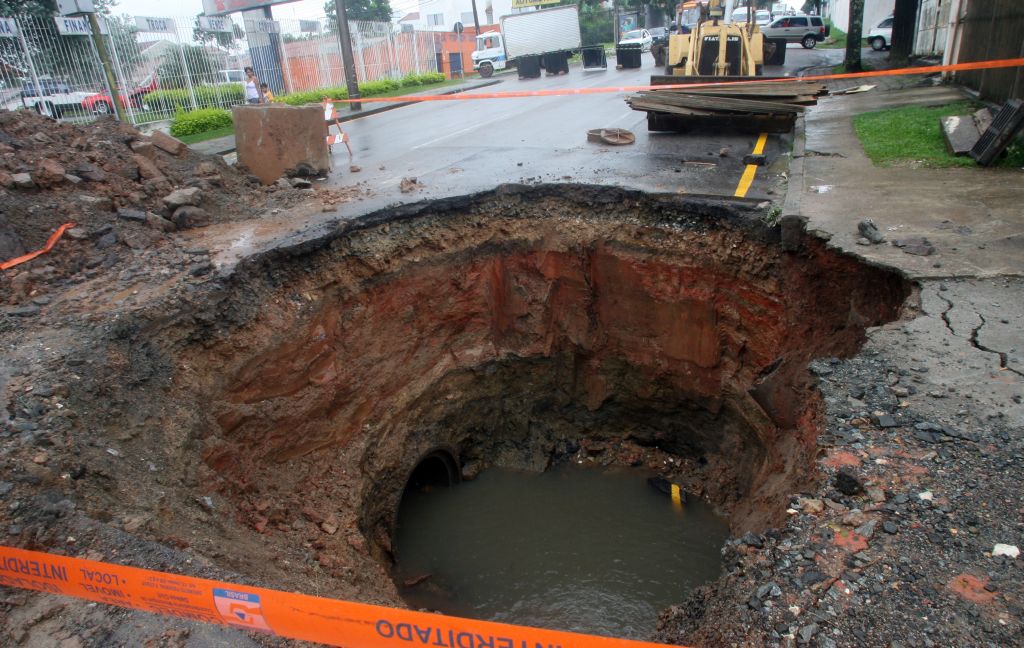 O excesso de chuva rompeu uma caixa de ligação de tubulações de águas pluviais, resultando em um buraco de 20 m2 | Priscila Forone/Gazeta do Povo