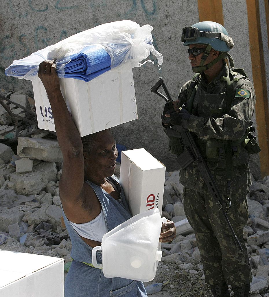 Haitiana carrega kit de ajuda doado pela ONU. Segurança do país está sendo feita pelos militares brasileiros da organização internacional | Reuters