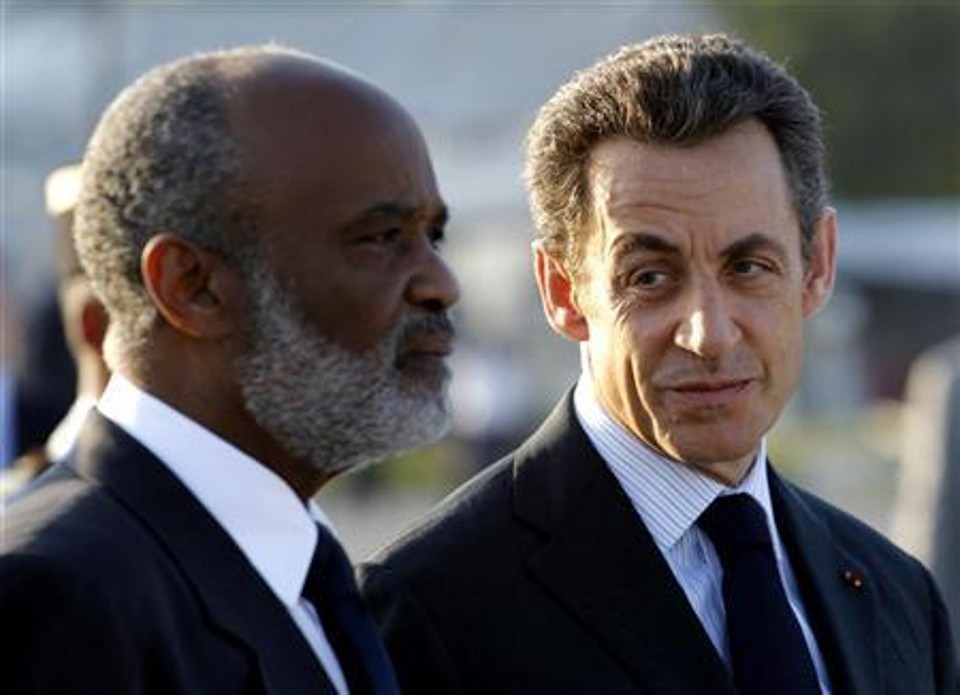 O presidente francês, Nicolas Sarkozy, ao lado do presidente haitiano, René Préval, participa de cerimônia de boas vindas no aeroporto internacional de Porto Príncipe | Reuters