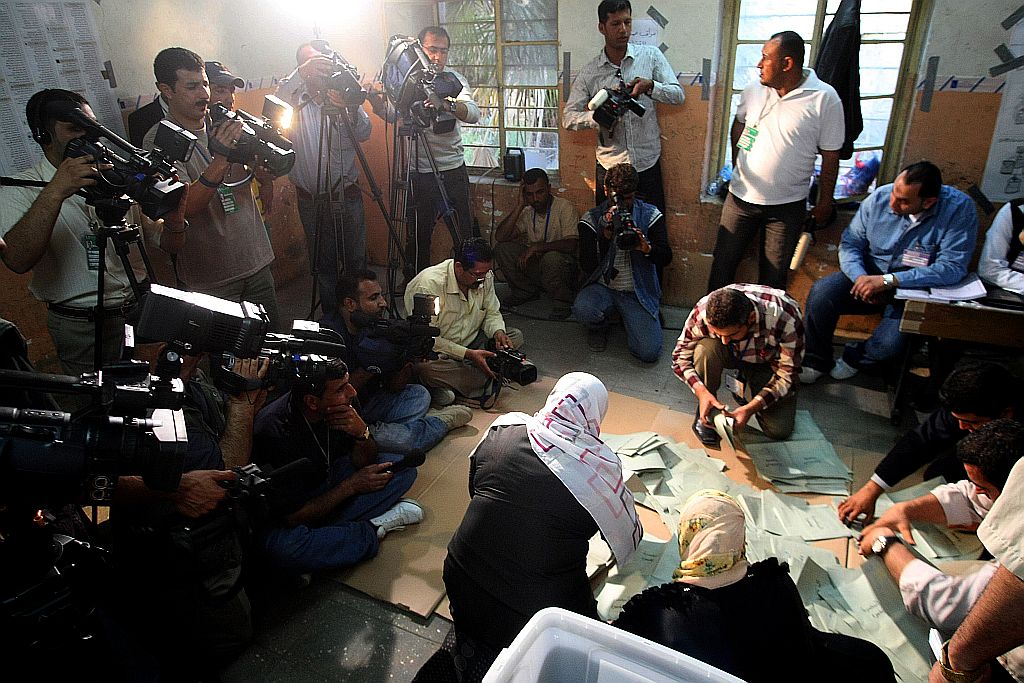 Câmeras de tevê e de outros meios de comunicação acompanham a contagem dos votos depois do fim da votação no sudeste da cidade de Basra | Essam Al-Sudani/AFP
