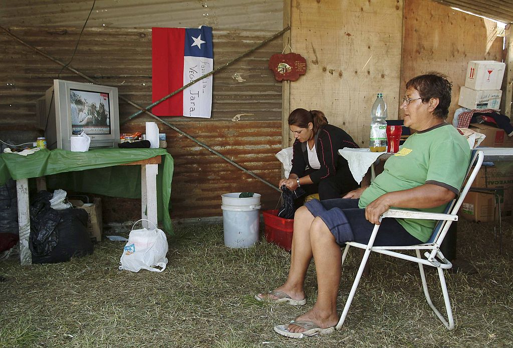 Sobreviventes do terremoto assistem televisão num abrigo temporário após perderem suas casas, em Concepción | Jose Luis Saavedra/Reuters