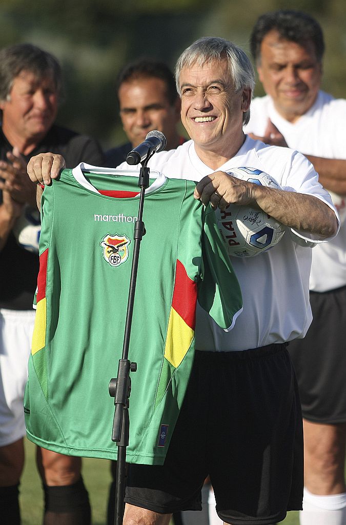 O presidente eleito do Chile, Sebastian Piñera, mostra camisa boliviana após partida de futebol solidária | Marco Fredes/Reuters
