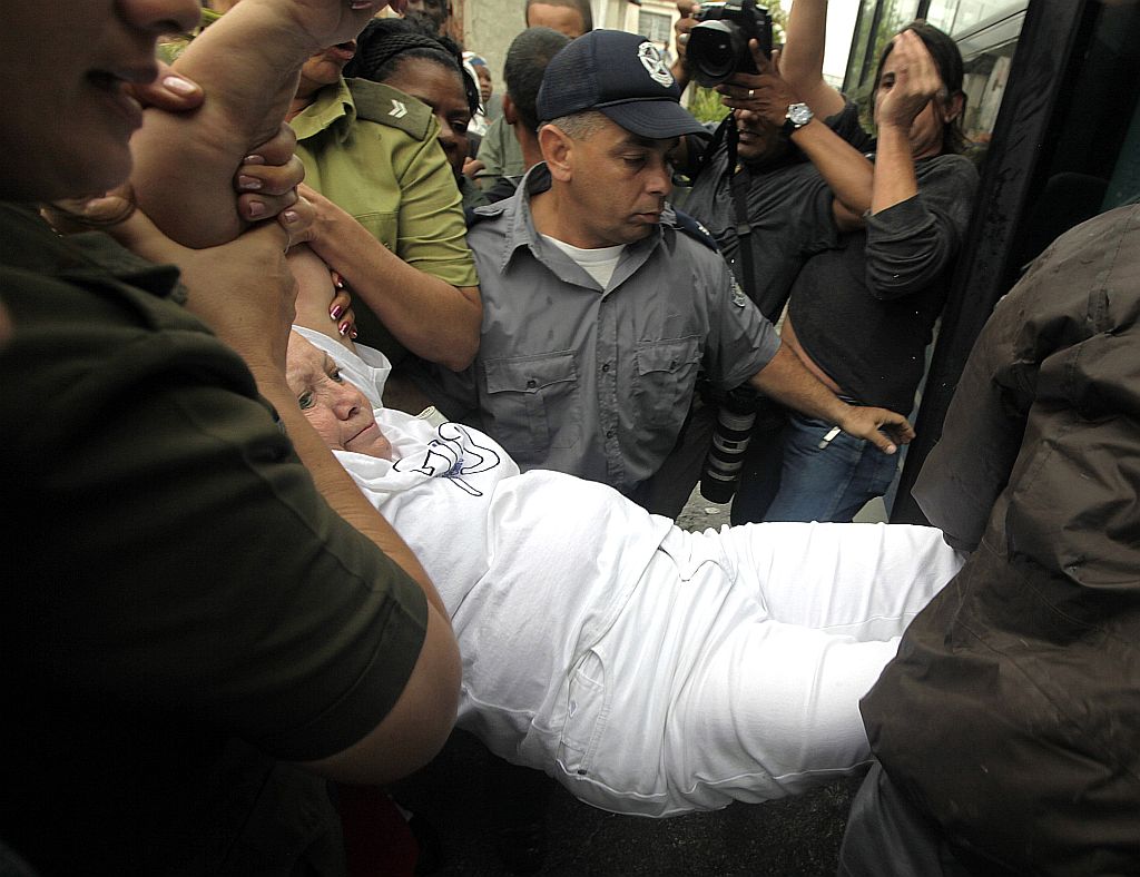 Seguranças cubanos carregam uma das Damas de Branco para um ônibus | Enrique De La Osa/Reuters