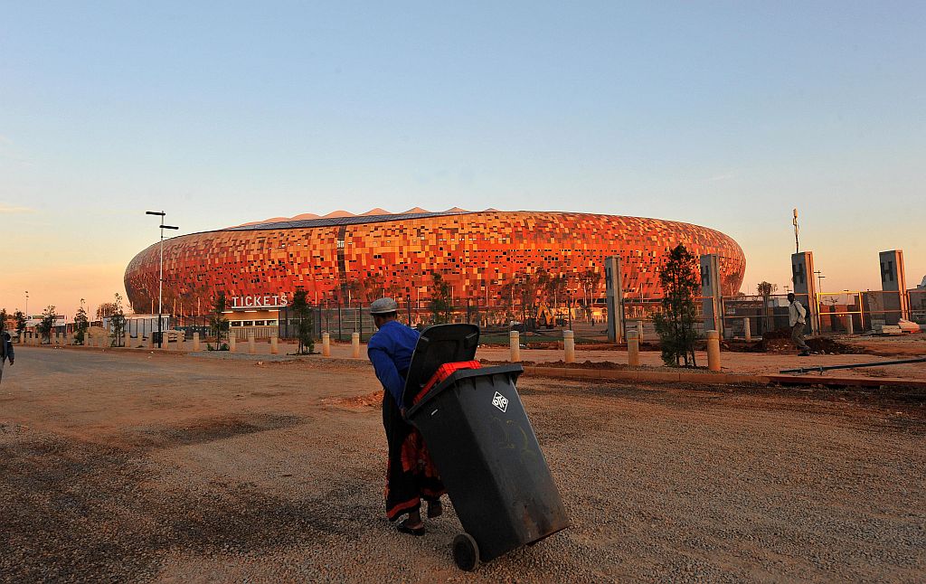 Um operá rio solitário passa pelo estádio do Soweto: hoje faltam 100 dias para o jogo de abertura do Mundial | Alexander Joe/AFP