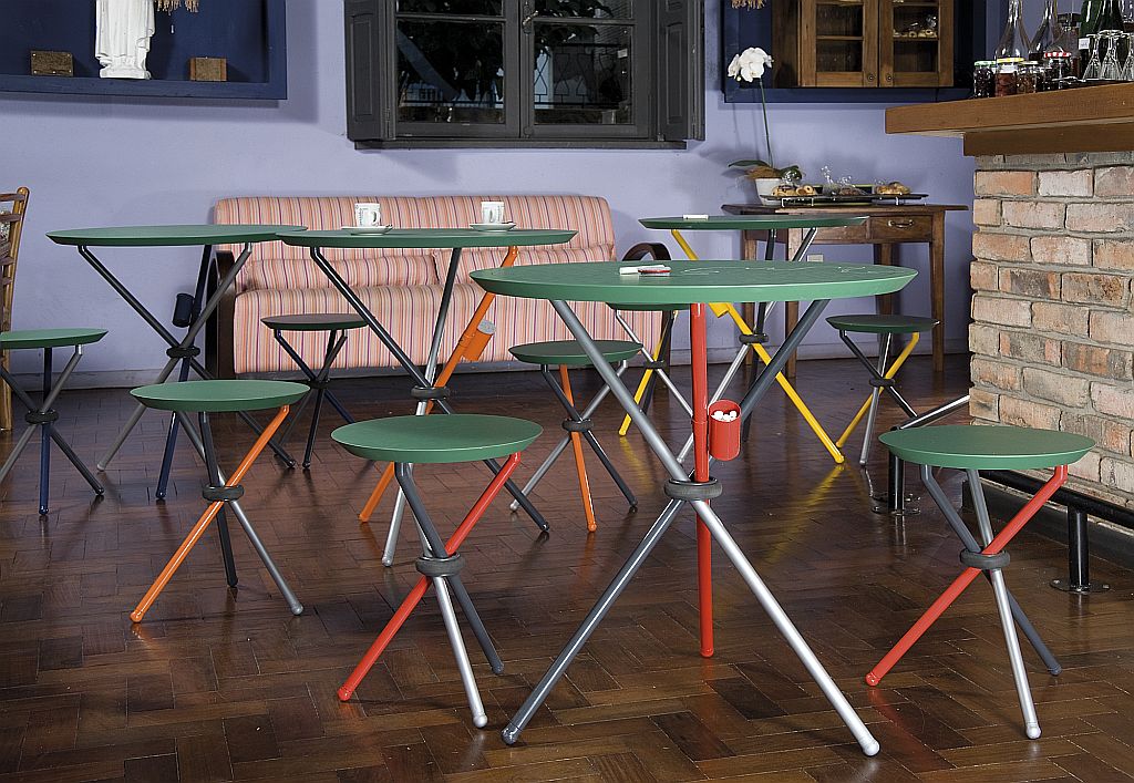 Mesa-bar da linha Quebra-cabeça, produzida pela Prima Design. São quatro tampos diferentes com caça-palavras, palavras cruzadas, labirinto e liga-pontos. Acoplado aos pés está um porta-giz | Prima Design/Divulgação