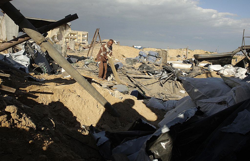 Palestino caminha em área atingida por ataque israelense desta sexta-feira (19). Ofensiva foi represália a atentado terrorista | Reuters