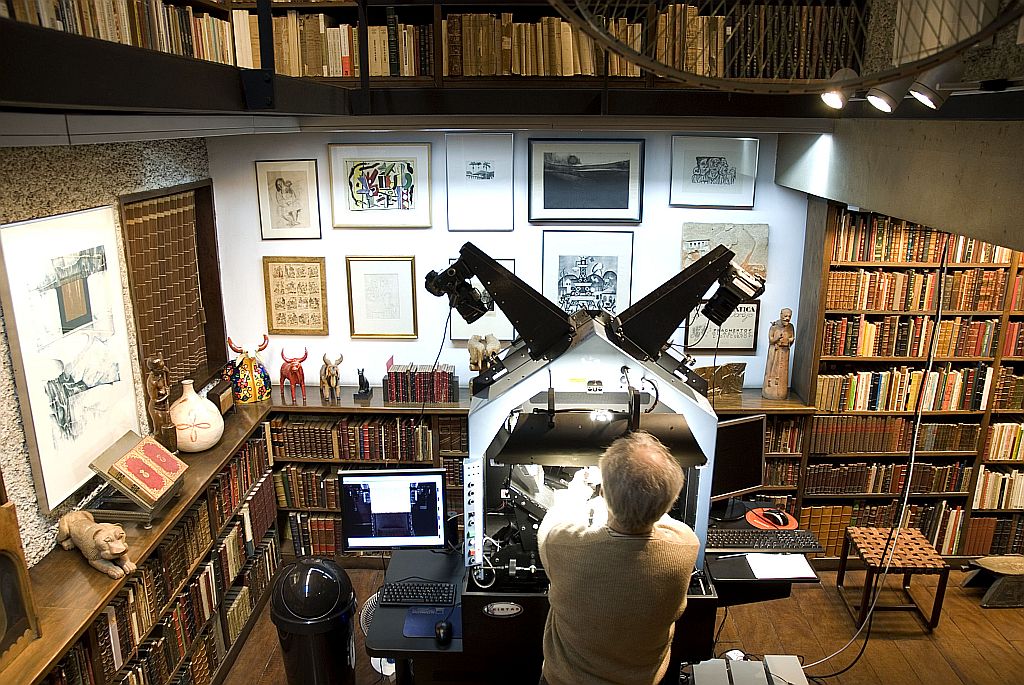 Integrante da equipe que realiza o processo de digitalização do acervo de José Mindlin, com um scaner digital Kirtas Apt 2.400 RA, na biblioteca da casa do bibliófilo | Lucia Loeb/Divulgação