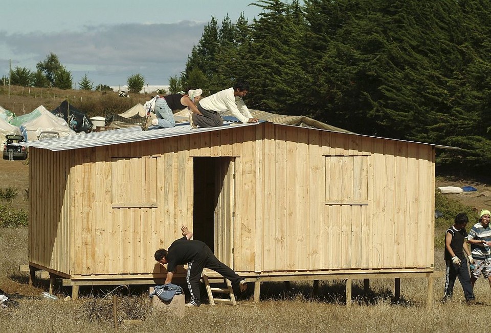 Voluntários trabalham na construção de casas no Chile. Cerca de 200 mil casas foram destruídas pelo terremoto | Reuters