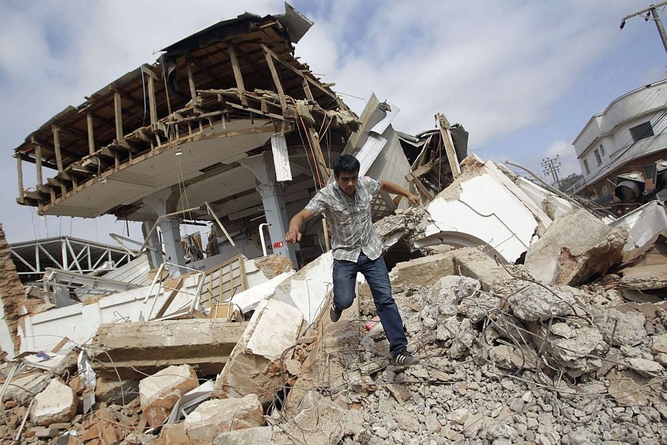 Chileno caminha sobre os destroços de uma construção no Chile. Governo está providenciando ajuda aos desabrigados pelo terremoto | Reuters