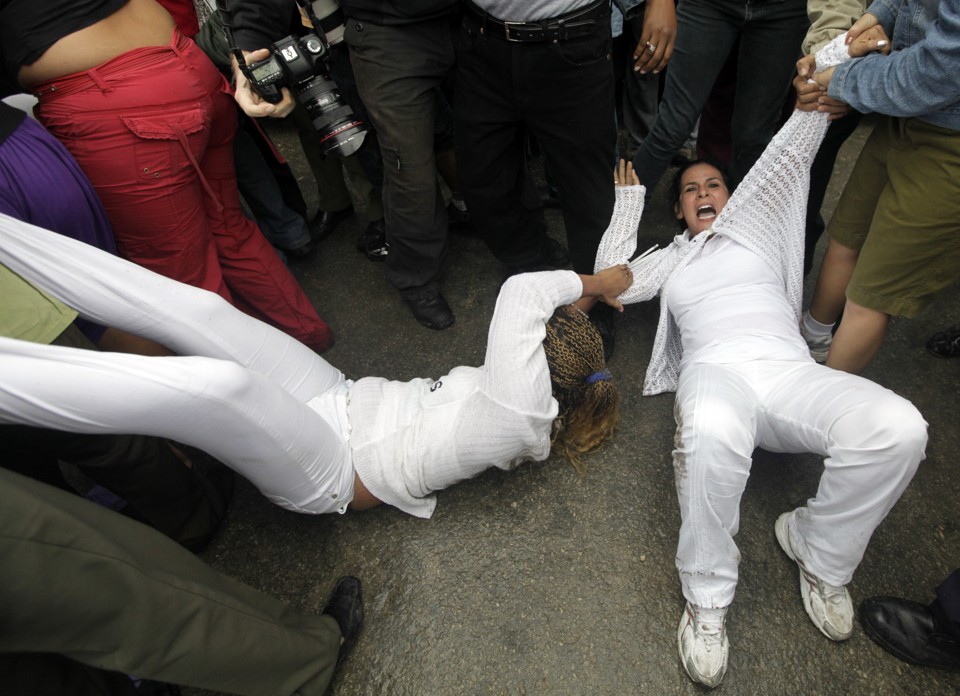 As roupas brancas que as mulheres tradicionalmente vestem ficaram enlameadas porque elas resistiram à ação das policiais | Reuters