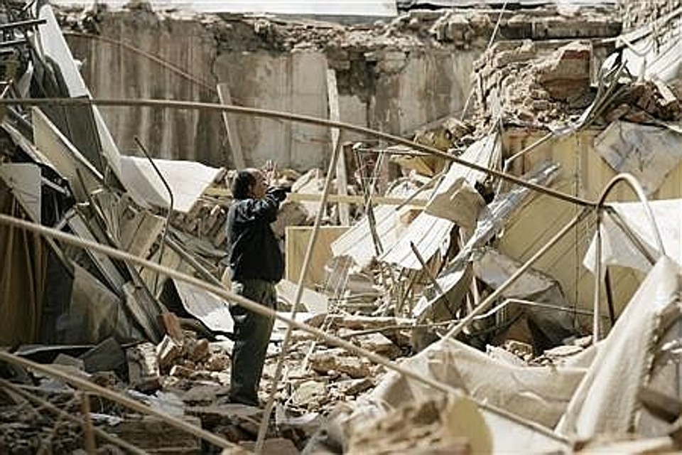 Homem observa o que restou de um prédio no Chile | Reuters