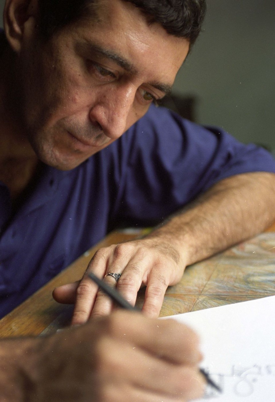 O cartunista Glauco em dois momentos: produzindo as tiras que diariamente eram lidas em todo o país | Otávio Dias de Oliveira/Folha Imagem