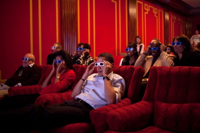 ... aos tempos de Obama -O atual presidente dos Estados Unidos, Barack Obama (de branco), e a primeira-dama Michelle assistem ao Super Bowl 2009 em uma sessão 3D no cinema privativo da Casa Branca. Obama é tido como o presidente mais 