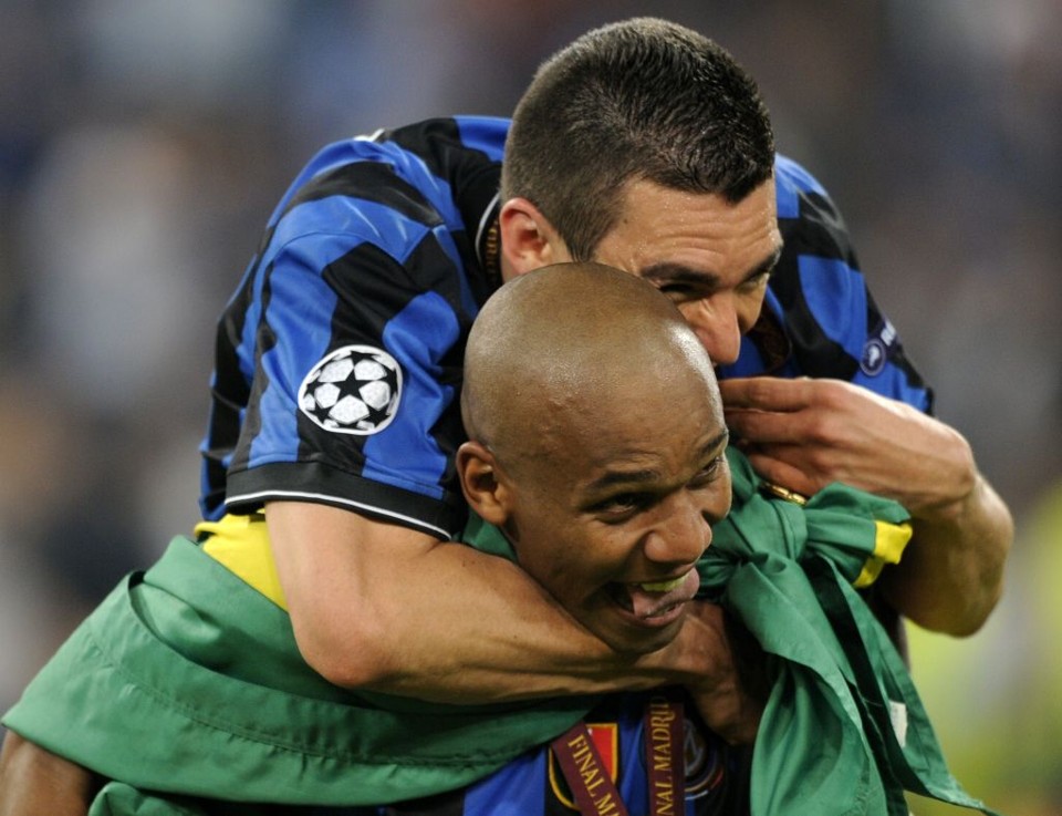Maicon, embrulhado na bandeira do Brasil, recebe o abraço de Lúcio durante a comemoração do título da Liga dos Campeões | Pedro Armestre/ AF