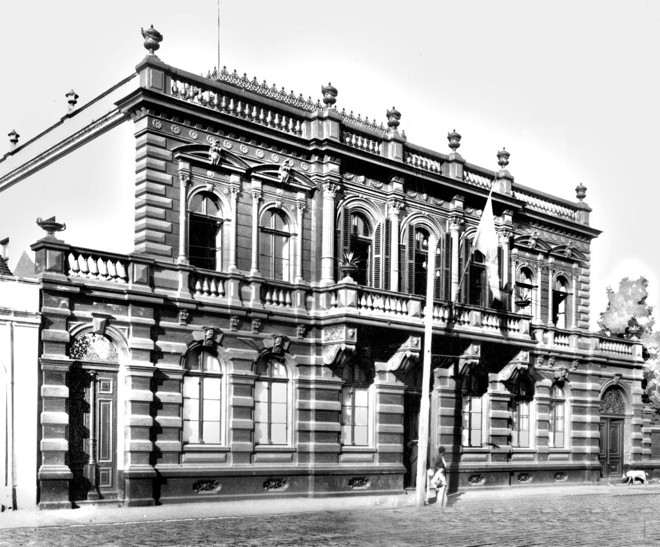 Em Curitiba, para quem é observador, existem muitas construções antigas. Muitas delas, com grande importância para a história local, parecem estar abandonadas, relegadas ao esquecimento do que já foram. Um exemplo que nos salta à vista é o do antigo prédio da Rua Barão do Rio Branco, onde poucos anos atrás funcionou o Museu da Imagem e do Som. Durante mais de trinta anos, no século passado, o imóvel foi sede do Palácio do Governo. Hoje, um enorme casarão desativado que mexe com a imaginação dos passantes. Foto de 1900 | 