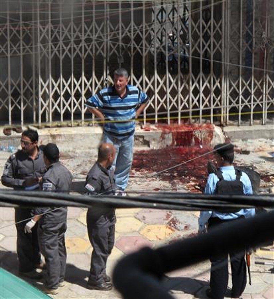 Seguranças se reúnem perto de ourivesaria após um ataque em Bagdá, 25 de maio de 2010. Pistoleiros mataram 14 pessoas em assaltos a ourivesarias de Bagdá, numa ousada ação em que levaram ouro e dinheiro, segundo uma fonte do Ministério do Interior. | REUTERS/Mohammed Ameen