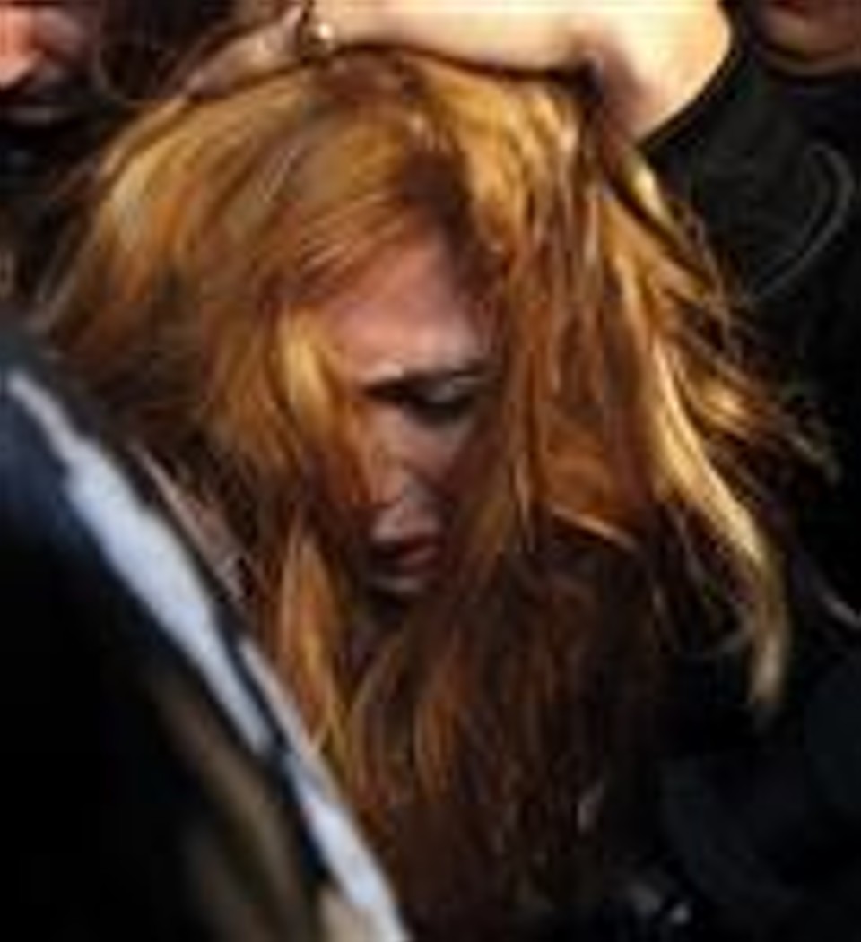 A modelo Angie Sanclemente Valencia é escoltada pela polí­cia após ser presa em um albergue em Buenos Aires. | REUTERS/Marcos Brindicci