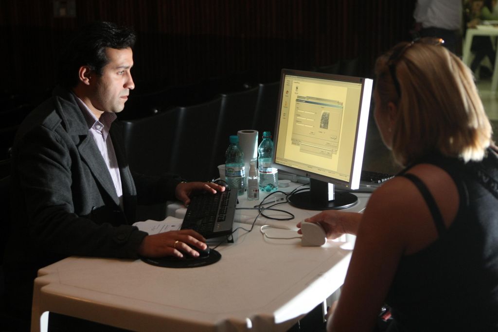 O funcionário da primeira secretaria Juliano Campelo tira a impressão digital de servidora para o recadastramento na Assembleia: não se sabe quantos comissionados serão recontratados | Albari Rosa/ Gazeta do Povo