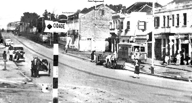 Alguns leitores devem lembrar quando alguém dos bairros dizia que ia até o centro e se referia desta forma: Vou até a cidade! Isso acontecia para quem morava no Batel, na Água Verde ou no Juvevê. Pois bem! Até acho que o pessoal tinha razão em se aludir ao centro da urbe como a cidade. Principalmente depois de ter encontrado esta fotografia do ponto de bondes do Juvevê, tendo uma placa indicando para a Avenida João Gualberto: Cidade. A foto é de 1950 | 