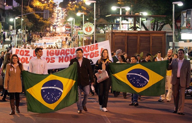 Em Foz, bandeiras e narizes de palhaço - Em Foz do Iguaçu, cerca de oitocentas pessoas marcharam pelas ruas da cidade e carregaram bandeiras. Por onde os manifestantes passavam, as lojas eram fechadas e luzes eram apagadas, numa demonstração de apoio. Muitos usaram narizes de palhaço. A comunidade árabe da fronteira deu apoio ao movimento. | 