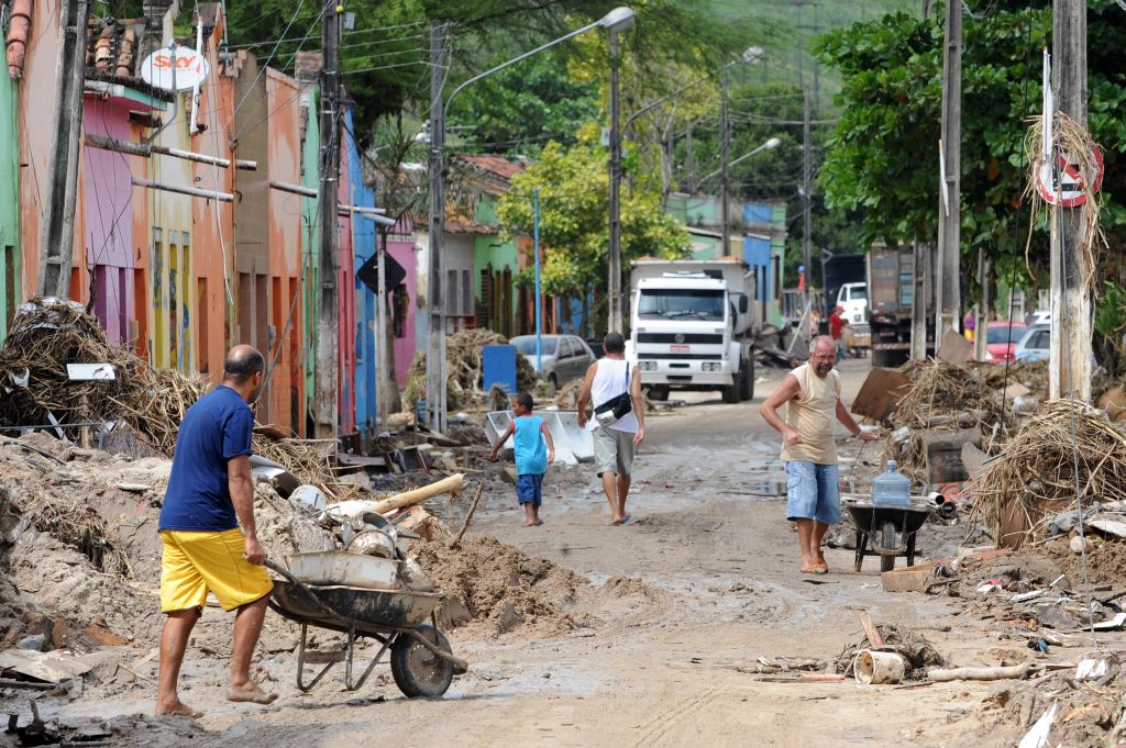 Moradores locais buscam objetos pessoais em área afetadas pelas chuvas em Branquinha, Alagoas | Evaristo SA / AFP Photo