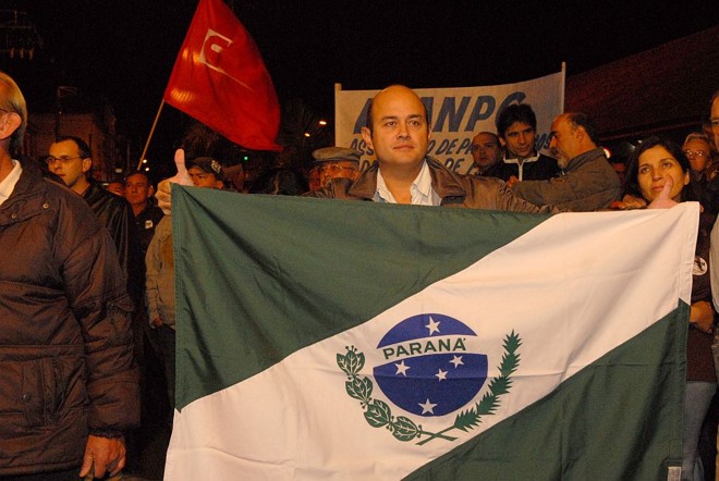 40 km para protestar - Com a bandeira do Paraná nas costas, o professor e cirurgião-dentista Giovatan de Souza Bueno viajou cerca de 40 quilômetros, de Palmeira para Ponta Grossa, para participar do ato público. 