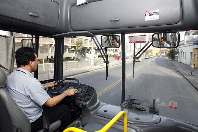 O motorista da linha Barreirinha desfruta da rua sem tráfego no momento da partida de estreia do Brasil na Copa do Mundo. Queria ver o jogo, mas um dia de trabalho sem buzina e congestionamento foi bem recebido | Hedeson Alves/ Gazeta do Povo