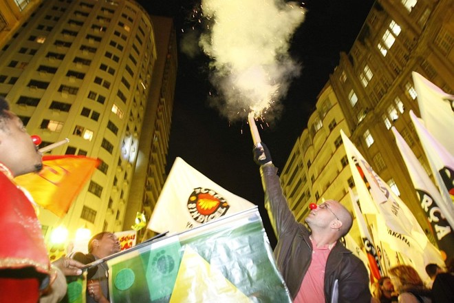 Manifestante solta fogos de artíficio e usa um nariz de palhaço, para protestar contra a forma como a Assembleia trata a população | 