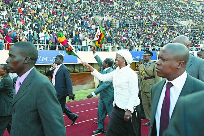 O presidente Robert Mugabe desfila com a bandeira do Zimbábue antes do jogo | 