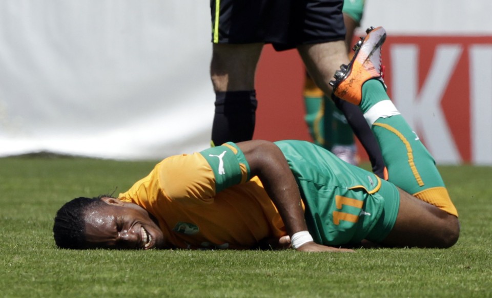 Drogba machuca o braço após trombada com brasileiro naturalizado japonês Marco Tanaka | Denis Balibouse / Reuters