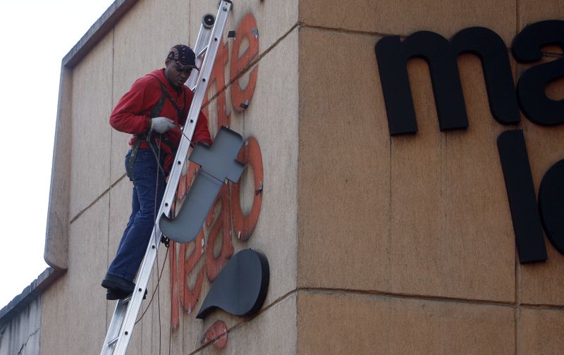 Operário retira letreiro do Matte Leão na esquina da João Negrão com Getúlio Vargas: golpe na memória fabril | Fotos: Hedeson Alves/Gazeta do Povo