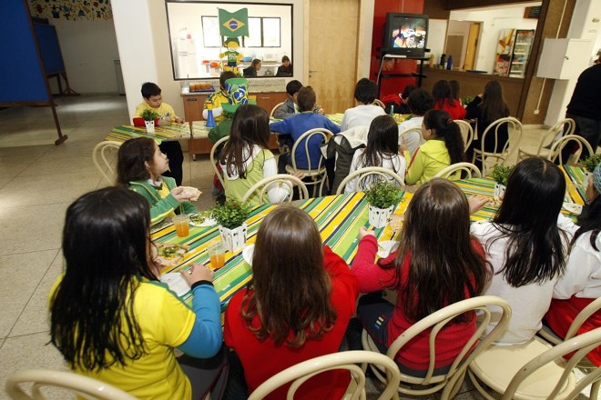 Alunos do Novo Ateneu assistem ao show de abertura da Copa em uma tevê na cantina. Os pais vão poder acompanhar os jogos do Brasil com seus filhos no colégio | Hedeson Alves/Gazeta do Povo