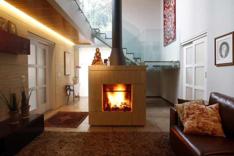Lareira a lenha, em limestone vermont e madeira, integra os ambientes da casa da empresária Ana Abreu | Daniel Derevecki/Gazeta do Povo