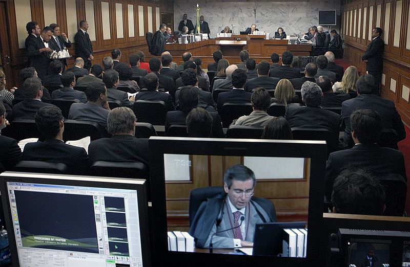 O ministro Arnaldo Versiani, na tela de um monitor do plenário do TSE, durante  a explicação de seu voto: Pouco importa o tempo verbal [da lei] | Nelson Jr./TSE