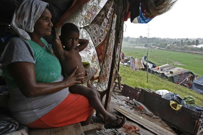 Vida no barraco improvisado -Com a destruição das casas e o aperto nos abrigos, muitas famílias fizeram moradias improvisadas com lonas, pedaços de madeira retirados dos escombros e lençóis. Sivanilda Maria da Silva vive em um deles com seis filhos e o marido, na cidade de Murici, em Alagoas. A base do barraco é a grama encharcada e a lona com furos permite que a água invada a moradia |