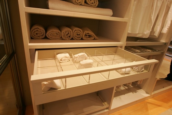 Acessórios como gaveteiros em acrílico e camiseiro retrátil são algumas opções no closet montado no showroom da Studio Florense. Esses elementos facilitam a visualização das peças e a organização do espaço |