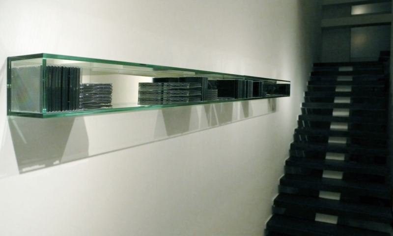 Porta-CD de parede, em vidro, da desiger Jacqueline Terpins: produto feito sob encomenda na Momentum & Design | Fotos: Divulgação