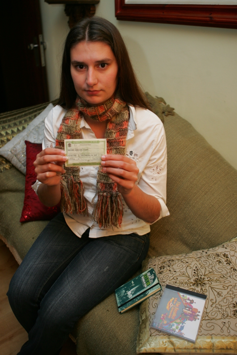 Mariana Cioffi, que estará na Inglaterra no dia da eleição, exibe o título de eleitor: regras diferentes para quem está no exterior | Aniele Nascimento/ Gazeta do Povo