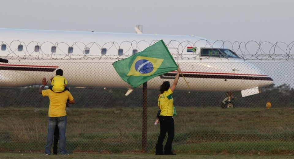 Torcedora brasileira se despede da seleção no aeroporto de Port Elizabeth. Delegação brasileira deixou o país da Copa em silêncio, mas com um curioso apoio popular | Fabrice Coffrini/AFP