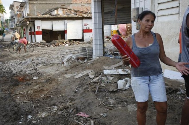 Mortadela dos destroços -Moradora da cidade de Barreiros, em Pernambuco, Cândida Maria Andrade Santos reclama que não recebe cestas básicas. O vizinho Anderson da Silva Santos, na mesma situação, entrou em um supermercado atingido pela enxurrada e retirou do meio da lama cinco pacotes de mortadela. Um deles deu para Cândida Maria, que aceitou prontamente |