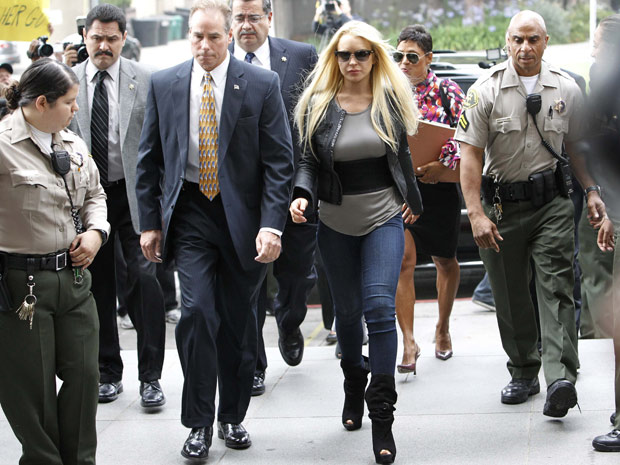 Atriz Lindsay Lohan chega a um tribunal de Beverly Hills ao lado da promotora Shawn Chapman Holley (atrás) para iniciar a cumprir sentença de 90 dias de prisão por quebra de condicional | REUTERS