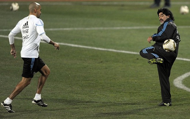 Meia Verón (esq.) e o técnico Maradona batem bola no treino da Argentina, que teve como grande ausência o astro Messi, vítima de uma gripe | 