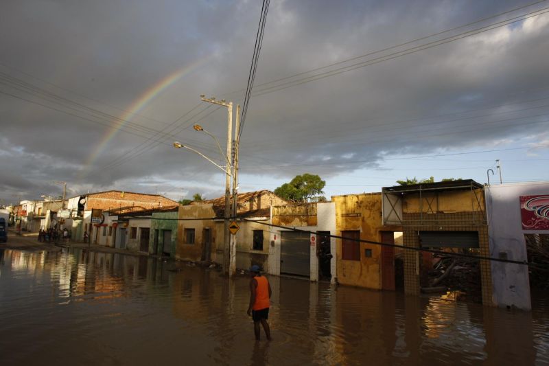 Homem caminha em meio à água da enchente em Murici: cidade de 27 mil habitantes tem 60% da população dependente do Bolsa Família | Fotos: Jonathan Campos/Gazeta do Povo