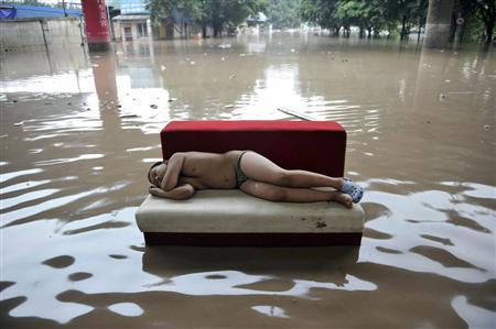 Criança dorme em rua inundada em Chongqing | REUTERS
