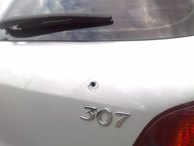 Um dos tiros atingiu a traseira do Peugeot |