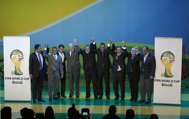 Orlando Silva (ministro do Esporte), Romário, Bebeto, Ricardo Teixeira, Lula, Cafu, Parreira, Blatter e Carlos Alberto Torres dão as mãos pela Copa 2014, no Brasil. Evento em Johannesburgo foi simbólico para o país assumir o posto de sede do próximo Mundial | 