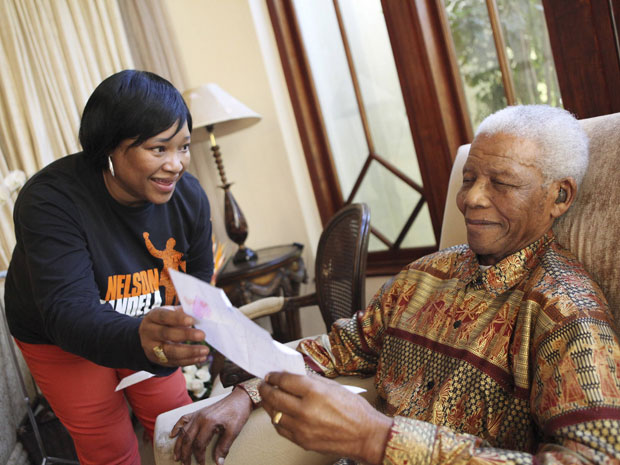 Zindzi Mandela, filha do ex-presidente, mostra ao pai um cartão de aniversário, neste sábado (17). | Debbie Yazbek/Fundação Nelson Mandela - Reuters