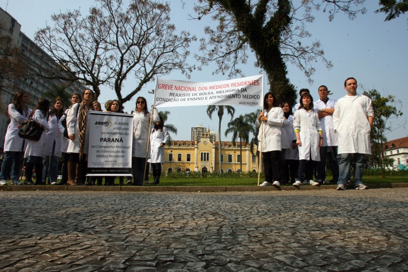Com a Santa Caso ao fundo, um pequeno grupo de médicos-residentes se reuniu ontem na Praça Rui Barbosa, em Curitiba, para protestar | Priscila Forone/Gazeta do Povo