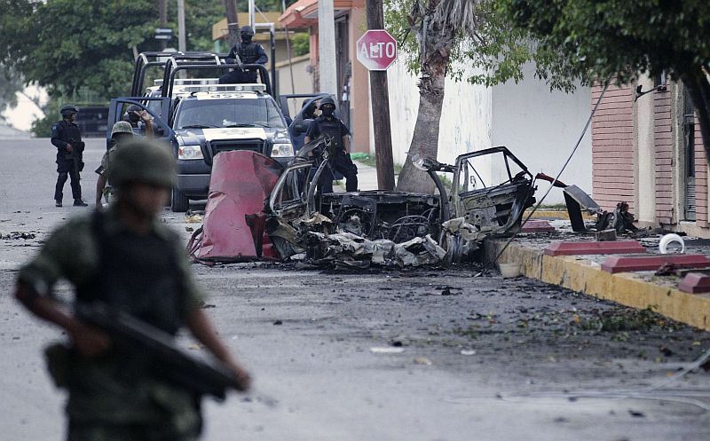 Policiais inspecionam o local onde uma das bombas explodiu, em Ciudad Victoria: intimidação | Henry Romero/Reuters